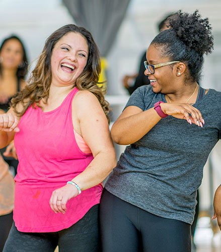 Två kvinnor ser glada ut och dansar fritt