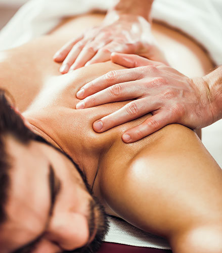 Man som ligger på massagebänk och får massage